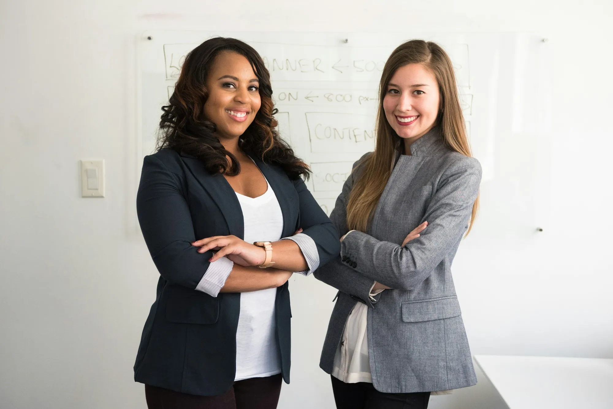 Two women clinicians standing together in an office